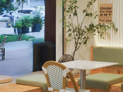 A cozy cafe interior featuring wooden seating and white plaster walls.
