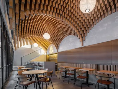 Industrial-style restaurant interior featuring a wooden ceiling and modern furniture.