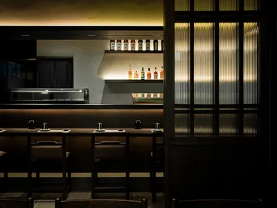 A modern restaurant interior with high glass ceiling and wooden seating