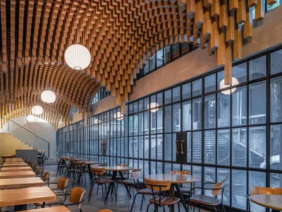 現代木質餐廳室內，懸掛燈具與大型窗戶。