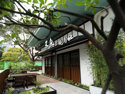 Outdoor seating area with wooden tables and chairs at a Japanese restaurant.