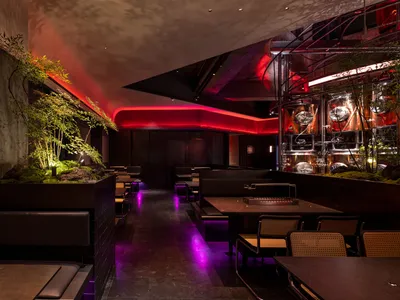 A modern industrial restaurant interior with metal decor and greenery.