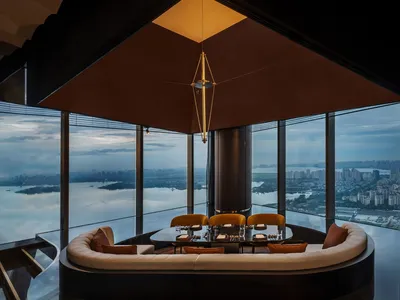 Modern restaurant featuring a glass ceiling and panoramic view of a cityscape.