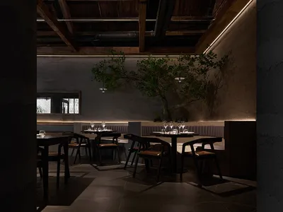 Modern restaurant interior with concrete walls and wooden beams and fixtures