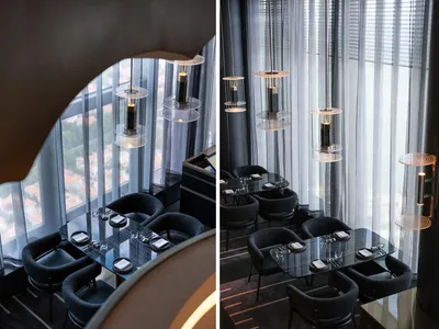 A modern restaurant interior featuring metallic lighting fixtures and glass elements.