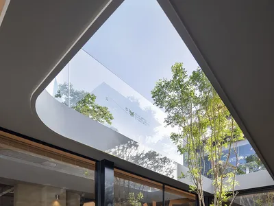 Modern restaurant interior featuring glass walls and concrete elements.