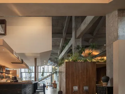 Industrial restaurant interior featuring wood, concrete, and metal materials.