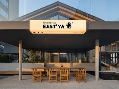 A minimalist restaurant exterior with concrete and glass materials.