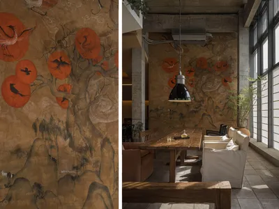 A modern restaurant interior featuring a wall art with floating orange circles and wooden furniture.
