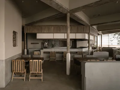 Industrial-themed restaurant interior with concrete finishes and minimalist design.