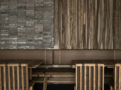 Industrial-style restaurant interior with wooden furniture and leather seating.