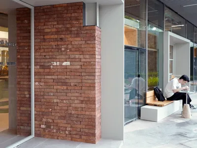 A modern cafe exterior featuring a red brick wall.
