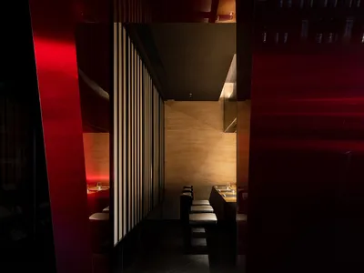 昏暗燈光下的餐廳室內，搭配木質牆面與座位安排。
