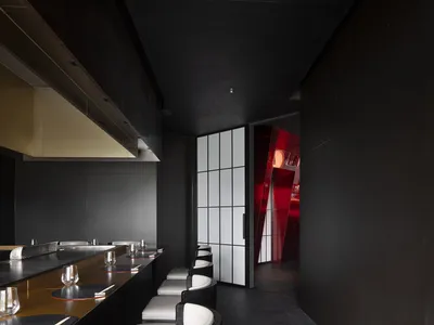 A modern restaurant interior with minimalist design and black and white color scheme.