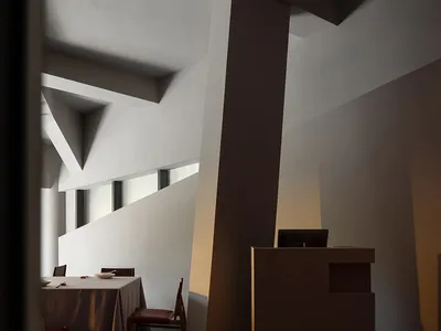 Modern interior with concrete walls, wooden tables, and warm lighting.