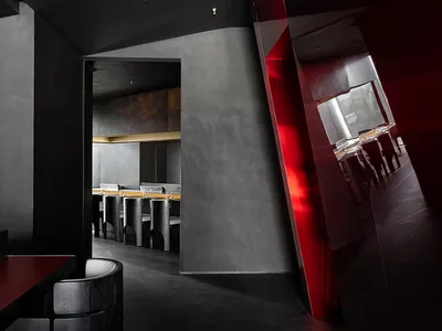 Contemporary restaurant interior featuring minimalist design with concrete and glass materials.