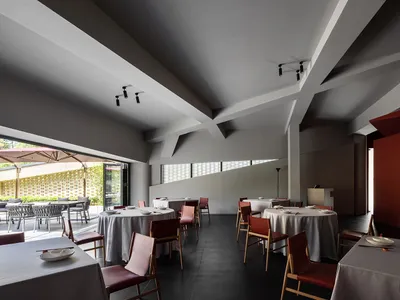 Modern, minimalist restaurant interior with neutral color palette and sleek, contemporary design elements.