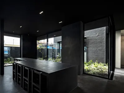 A modern restaurant interior with minimalist design, featuring industrial-style concrete furniture and fittings.