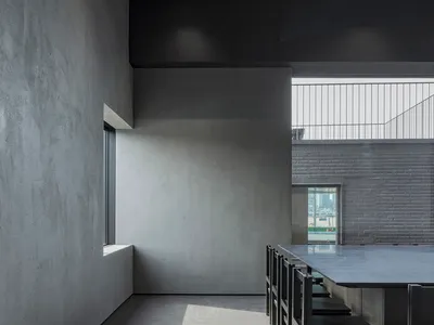 A minimalist restaurant interior with industrial materials and large windows.