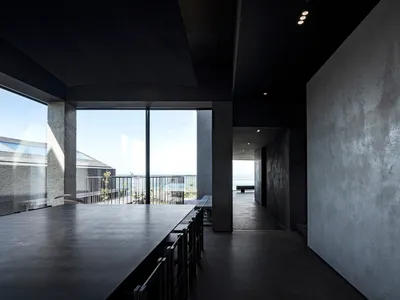 Interior of a minimalist restaurant with a concrete floor and walls.
