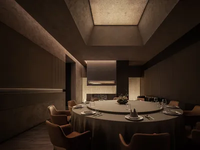 Modern restaurant interior with circular table, chairs, and concrete walls and ceiling.
