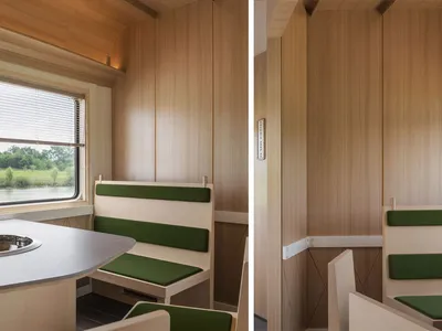 A modern restaurant private room with wooden walls and green fabric seating