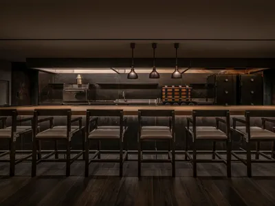 一間黑暗的工業風餐廳廚房，帶有金屬元素和長吧台。