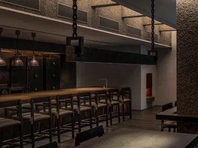 A modern industrial-style restaurant bar with brick and concrete walls.