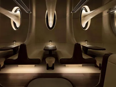 Modern restaurant with white leather booths and dark wood accents