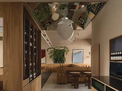 Modern restaurant interior design featuring wooden shelving, concrete flooring, and contemporary furniture.