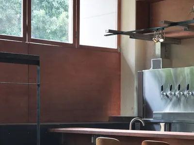 Modern restaurant bar with wooden furniture and a bar counter.