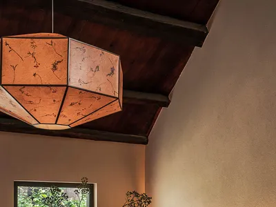 Dining room with wood accent wall, table, chairs, and floral arrangement, showcasing modern design elements.