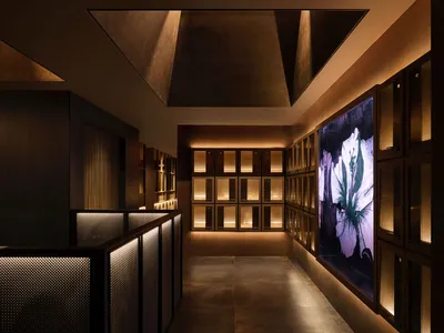 A modern business hotel suite featuring sleek metal railings, glass surfaces, and illuminated LED panels.