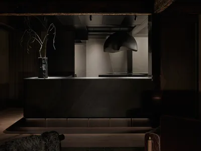 A modern dark metal and steel reception counter in a hotel lobby.
