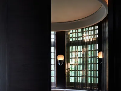 Circular booth seating area in a modern restaurant with concrete flooring and upholstered cushions.
