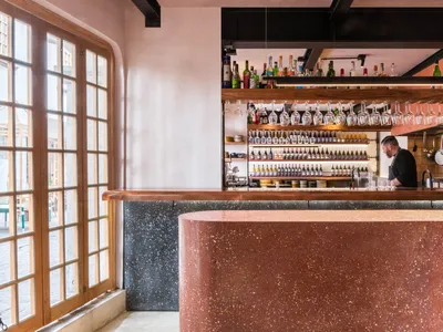 Industrial-style restaurant with wooden accents and a terrazzo countertop.