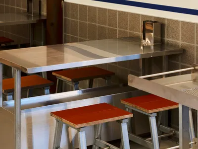Industrial-style restaurant interior with metallic counter and seating.