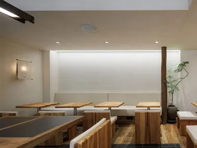 簡約風格的餐廳室內，搭配木質餐桌與混凝土牆面。