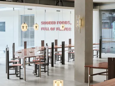 A modern restaurant interior with a concrete floor and minimalist decor.