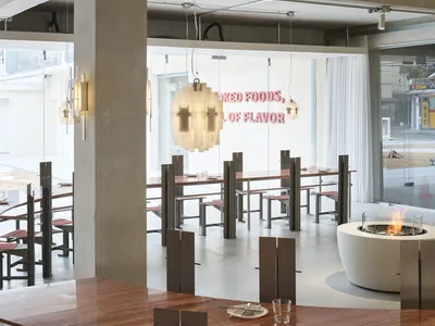 A stylish restaurant interior featuring modern concrete and wooden elements.