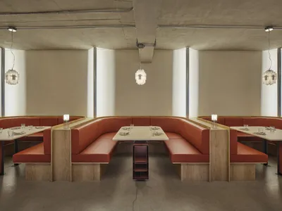 Modern restaurant interior with booth seating made of leather on concrete floor