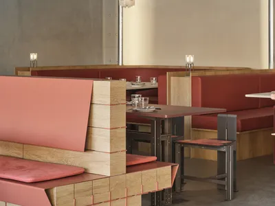 Modern restaurant interior with red upholstered benches and wood accents