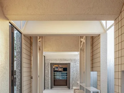 A modern restaurant with minimalist design features concrete and glass material.