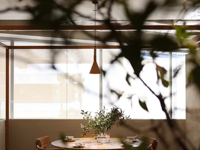 A cozy modern restaurant interior with wooden furniture and a round table.