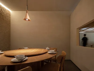 A modern restaurant interior featuring wooden furniture and a cozy atmosphere.