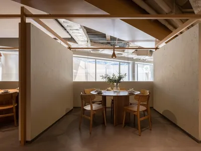 現代餐廳室內設計，搭配木質餐桌與混凝土地板，設有圓桌、座椅及簡約元素