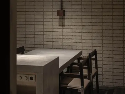 A minimalist kitchen with concrete countertops and walls.