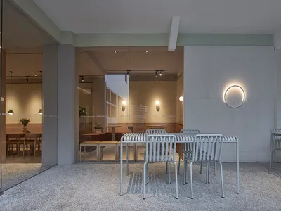 A modern restaurant interior featuring concrete tables and minimalist design elements.