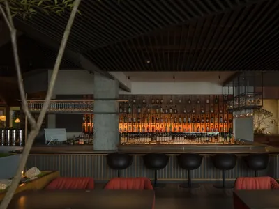 Modern restaurant bar interior with wood, concrete, and metal elements