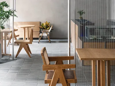A minimalist restaurant interior with wooden furniture, modern lighting, and green plants.